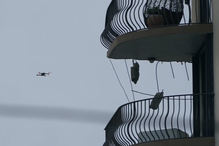 a drone flying next to balconies