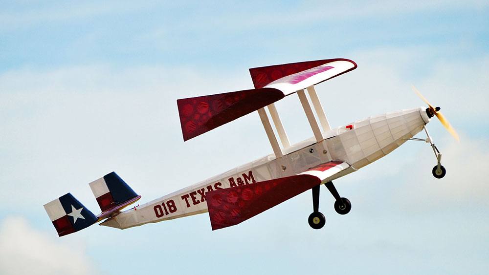 The biplane in flight against blue sky