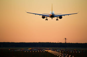 airplane approaching runway at sunset
