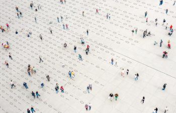 overhead artist's rendering of a crowd of people walking over binary code