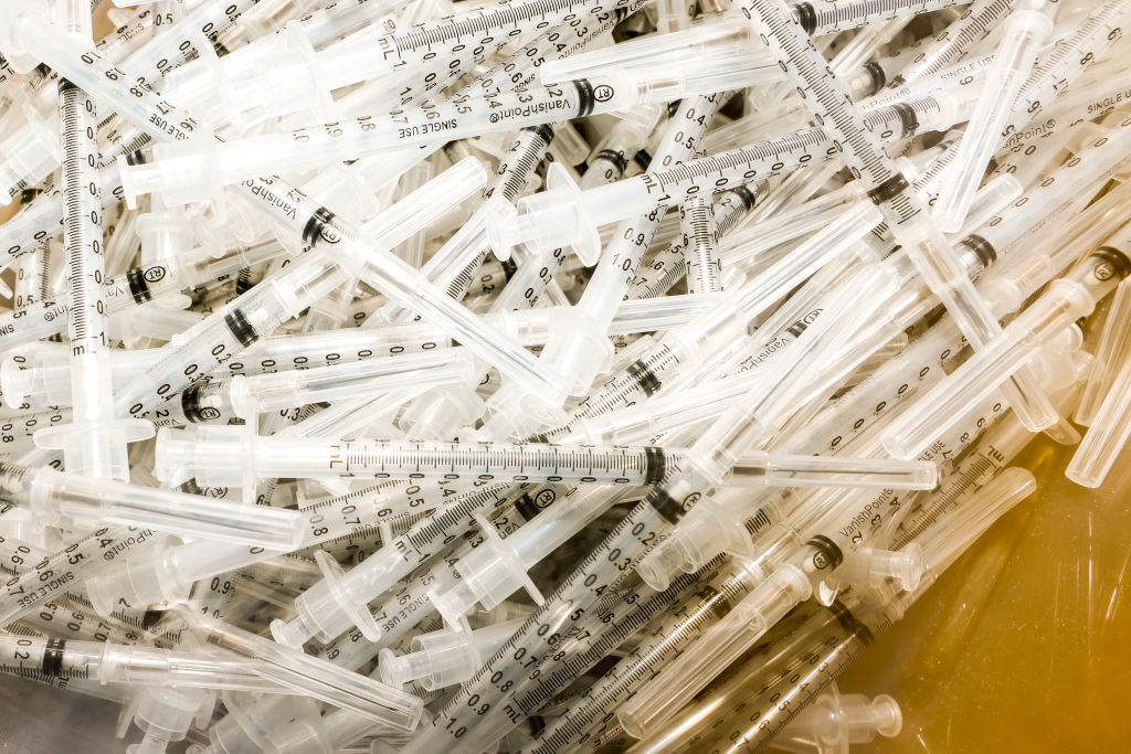 vaccine syringes sit in a pile