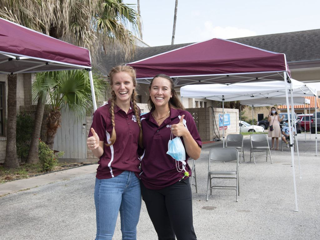 two female students giving the gig 'em