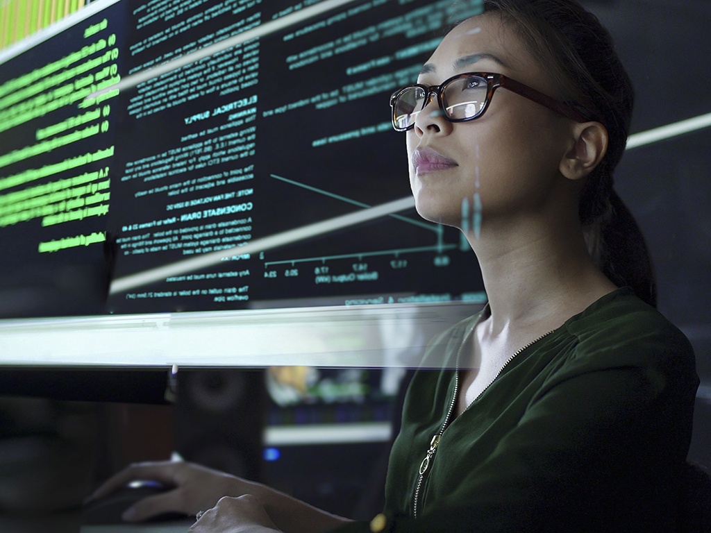 a photo of a woman looking at a computer screen