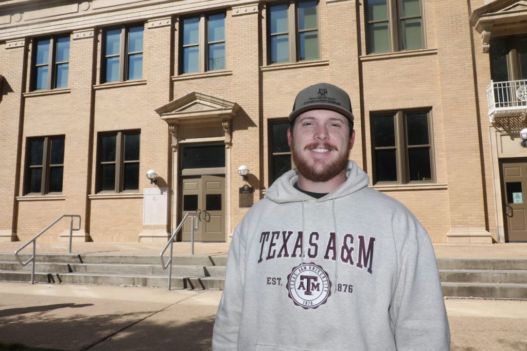 student standing in front of construction sciences building