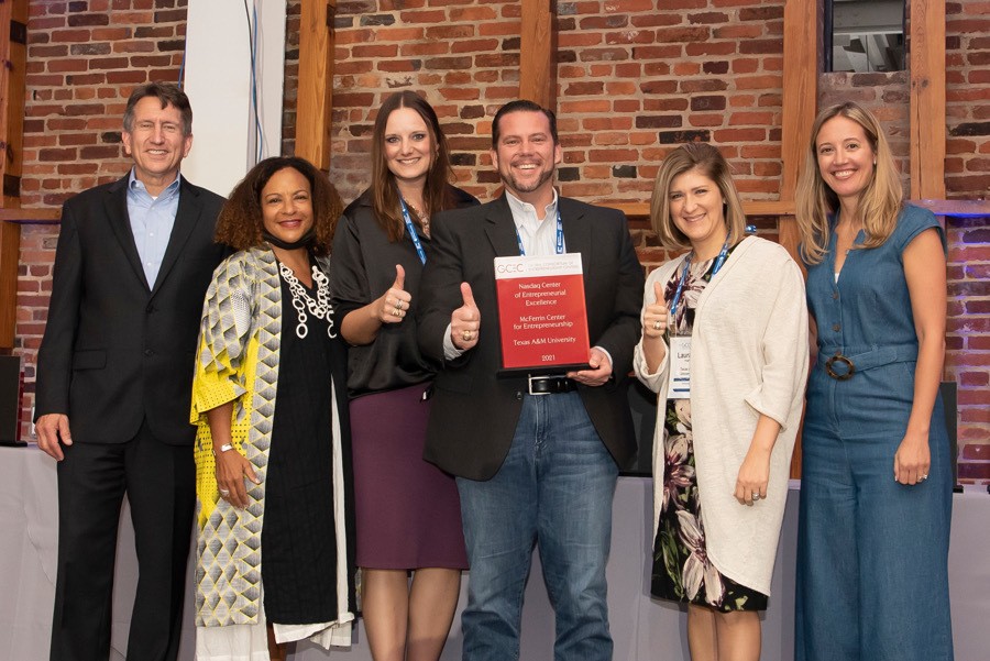 group photo posing with award