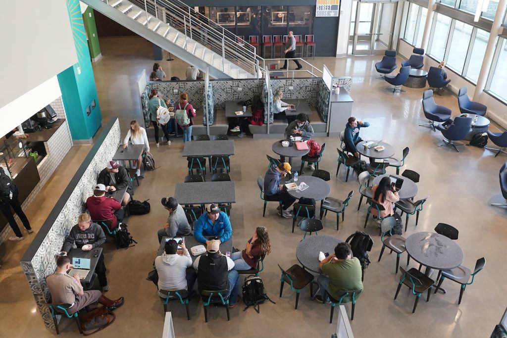 overhead view of students seated at round tables in a dining hall