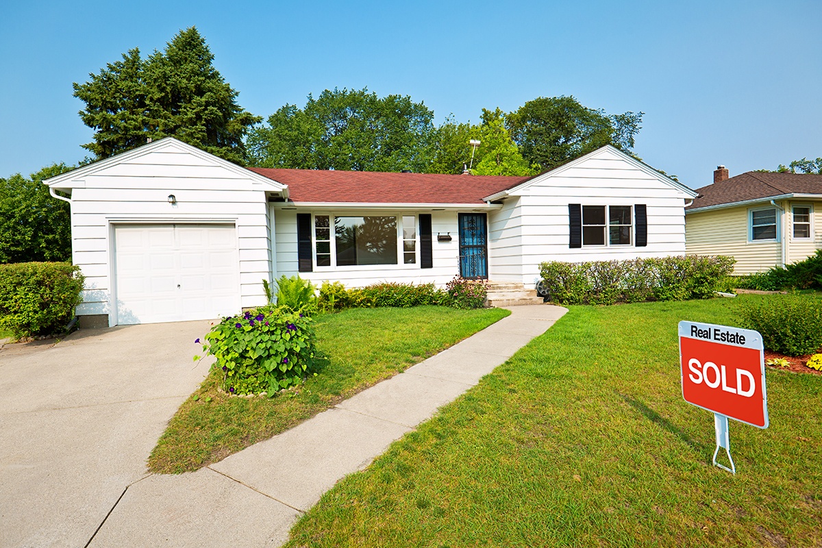a home with a sold sign on the lawn