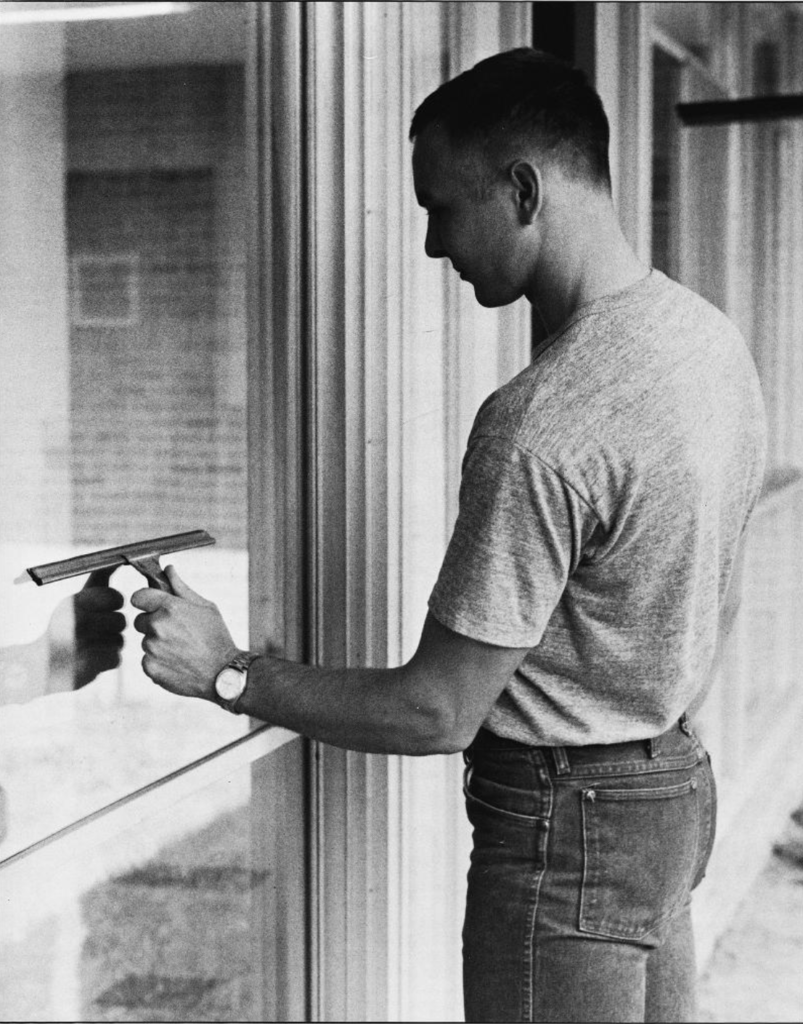 an Aggie student washing windows during The Big Event in 1983