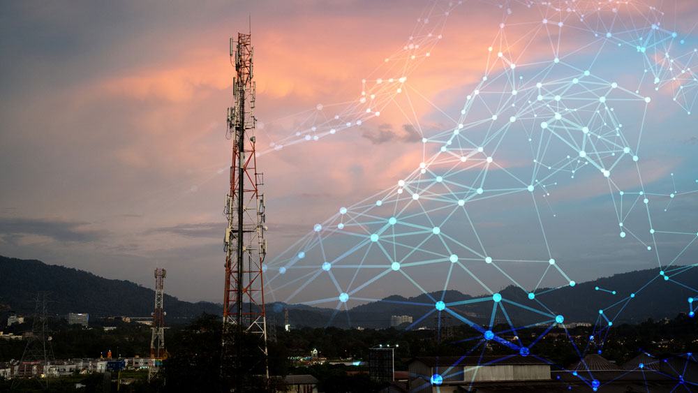 Artist's concept illustration of a wireless network layered over a photo of a cell phone tower against a sunset.