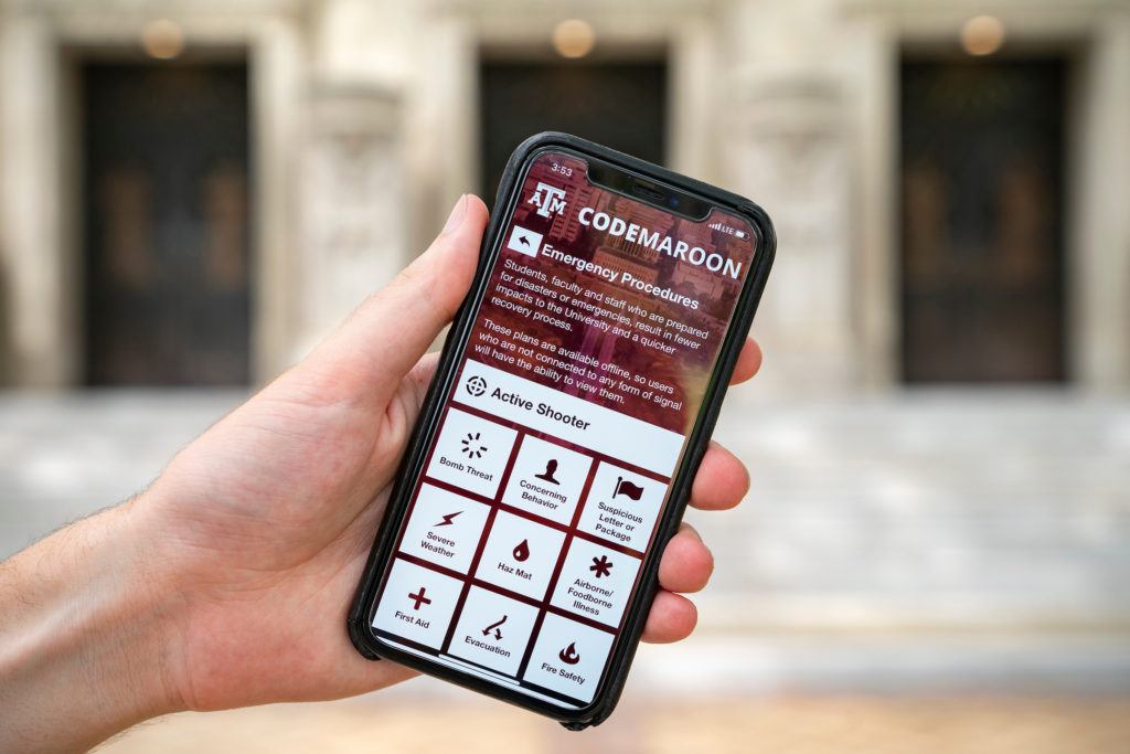a photo of a hand holding an iphone with the code maroon app open to the emergency procedures screen