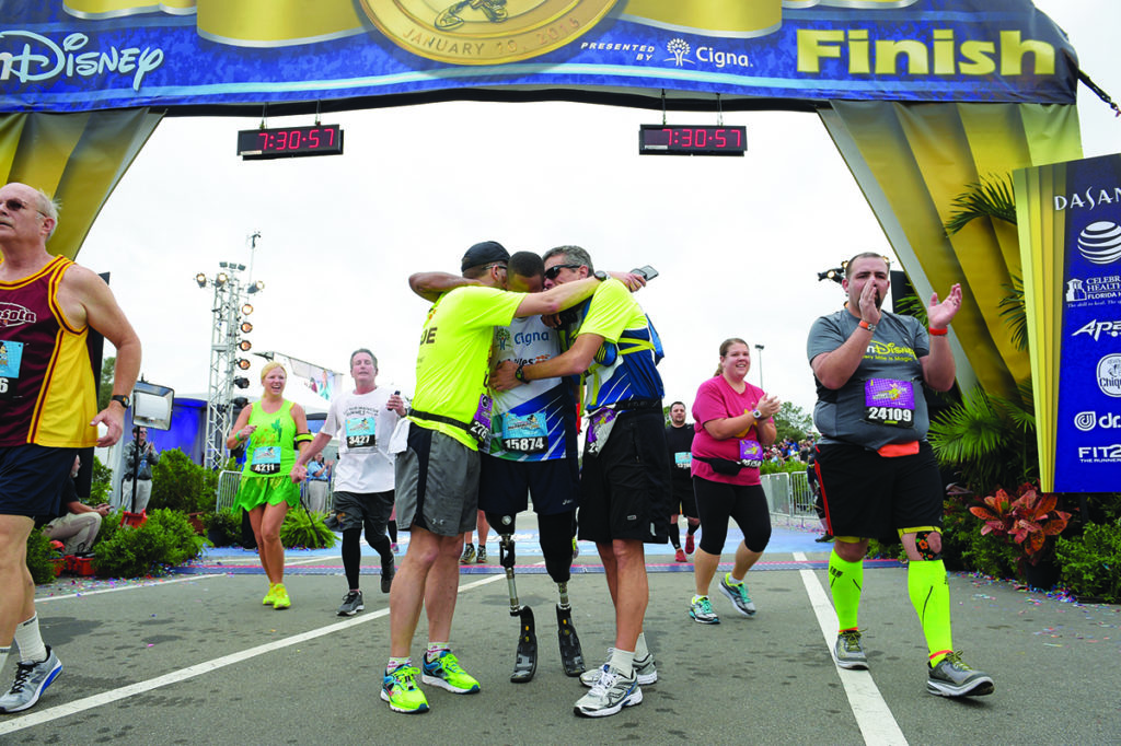 Cordani at the finish line with Cedric King during the Walt Disney World Marathon in Lake Buena Vista, Fla., Sunday, Jan. 10, 2016