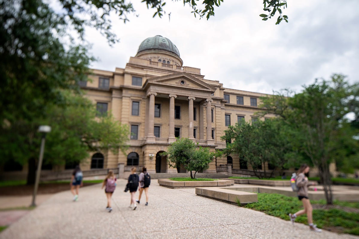 Exterior shot of students walking by the Academic Building on campus