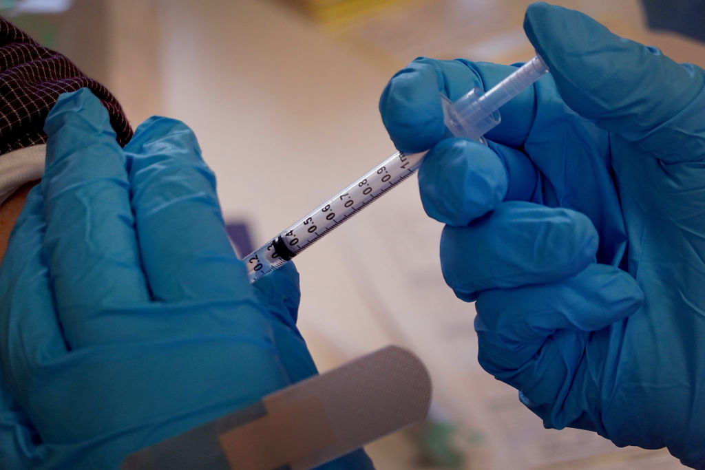 close up of gloved hands of a pharmacist administering a shot