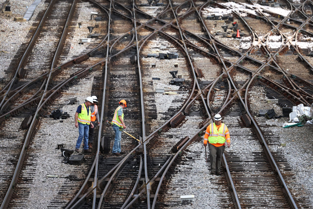 aerial view of railroad workers in yellow vests working on railroad tracks