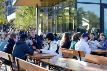 Students sitting at picnic tables outside the creamery