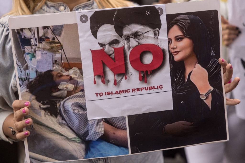ISTANBUL, TURKEY - OCTOBER 07: A woman holds a sign during a protest over the death of Iranian Mahsa Amini outside the Iranian Consulate on October 07, 2022 in Istanbul, Turkey. Mahsa Amini fell into a coma and died after being arrested in Tehran by the morality police, for allegedly violating the countries hijab rules. Amini's death has sparked weeks of violent protests across Iran. (Photo by Chris McGrath/Getty Images)