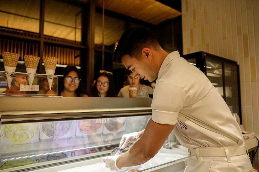 A Yell Leader scooping ice cream behind the counter