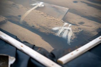 Close-up view of the submerged ship pieces. Long planks of wood sit under water.