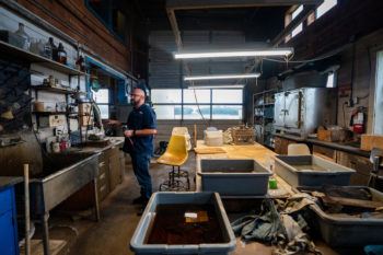 Dostal standing inside a room lined with work benches and tools