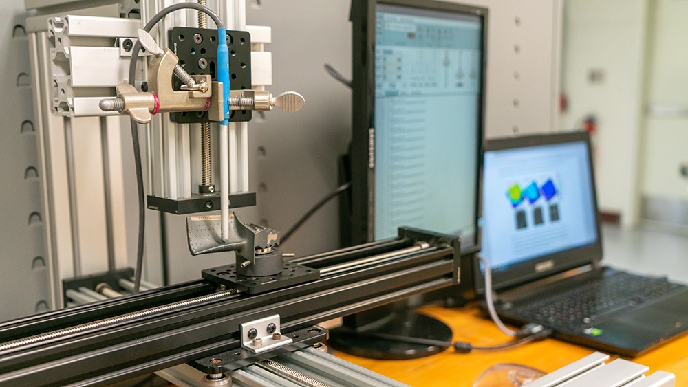 a photo of a machine with a sensor passing over a metal object