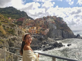 an Aggie standing seaside on a study abroad trip to Italy