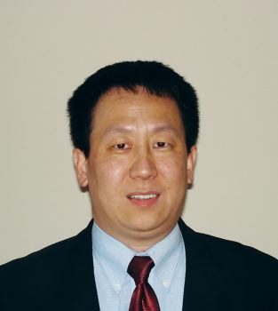 a headshot of a man in a suit with a red tie