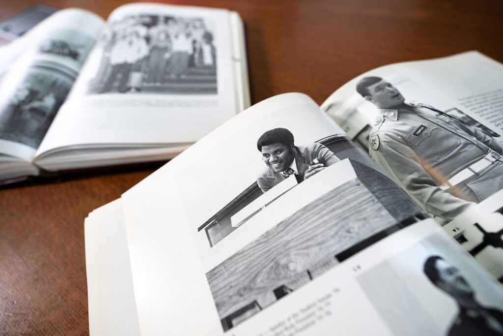 Yearbooks opened on a table, with the pages flipped to a black and white photo of McClure standing at a podium