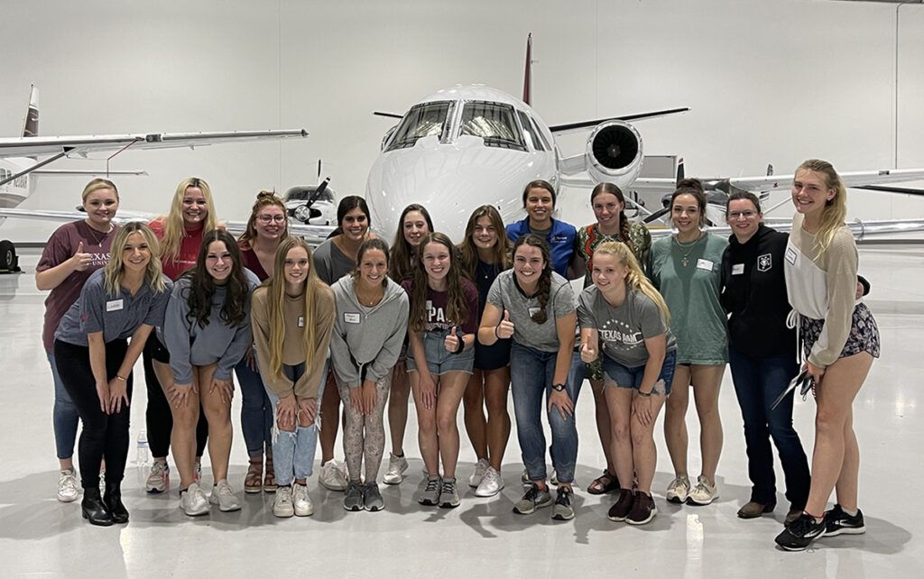 Texas A&M Women in Aviation in an airplane hangar
