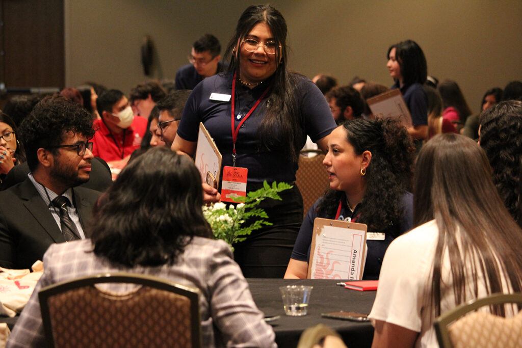 a woman speaking to others at the MSC SCOLA event in 2022