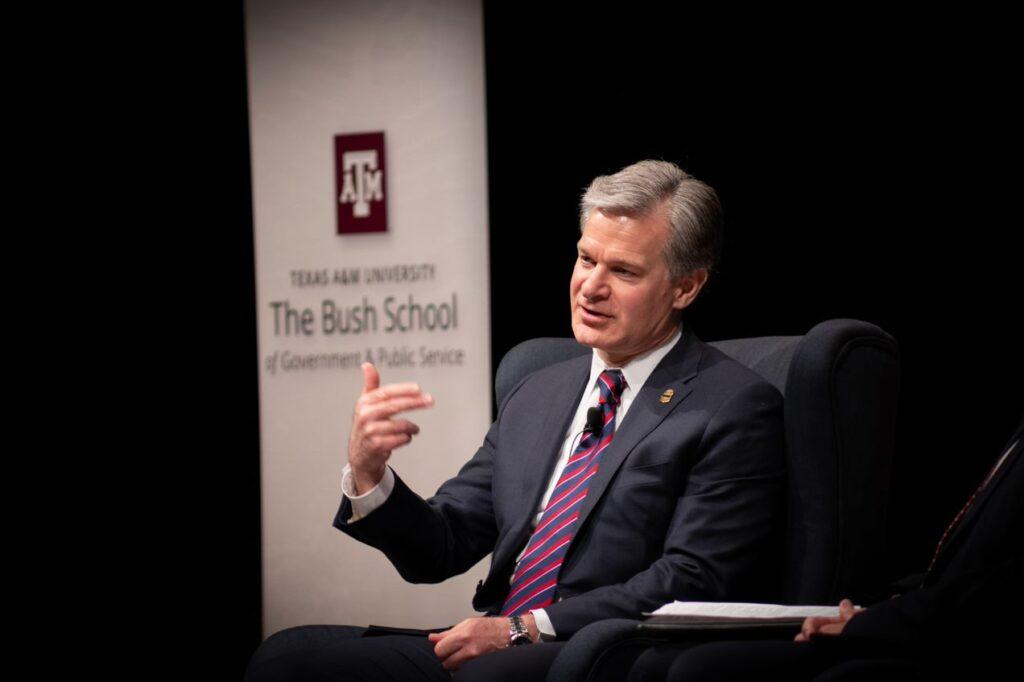 Christopher Wray seated on stage during talk.