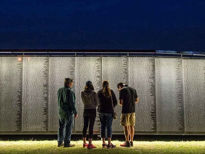 people standing before The Wall That Heals