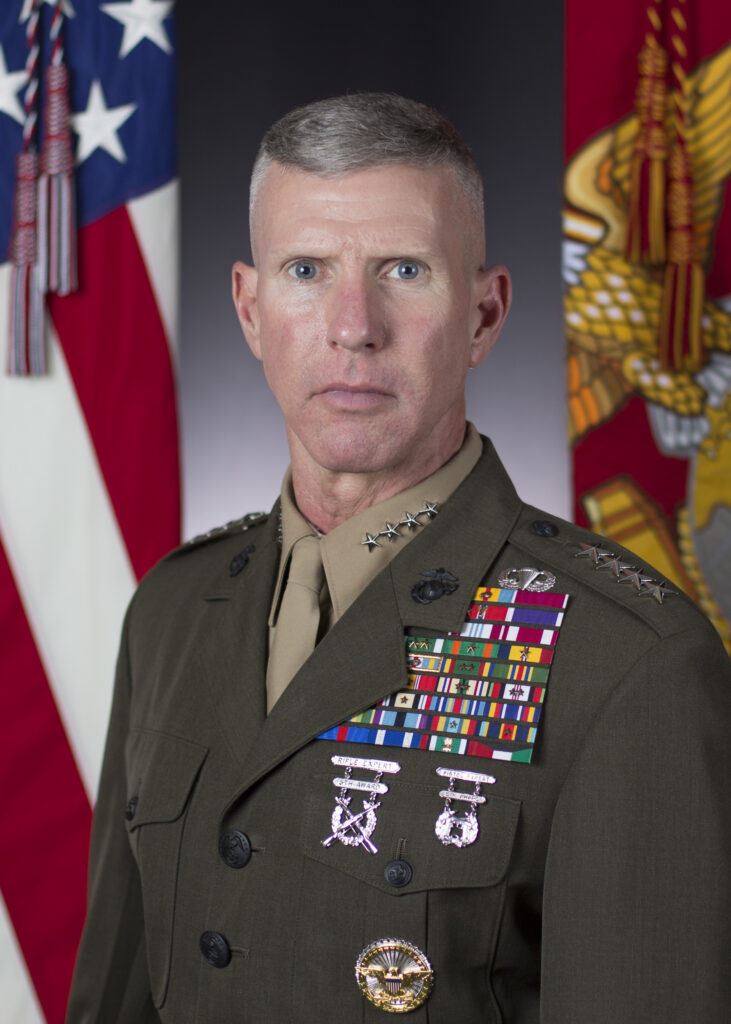 a portrait photo of Gen. Eric M. Smith in uniform seated in front of the U.S. and Marine flags