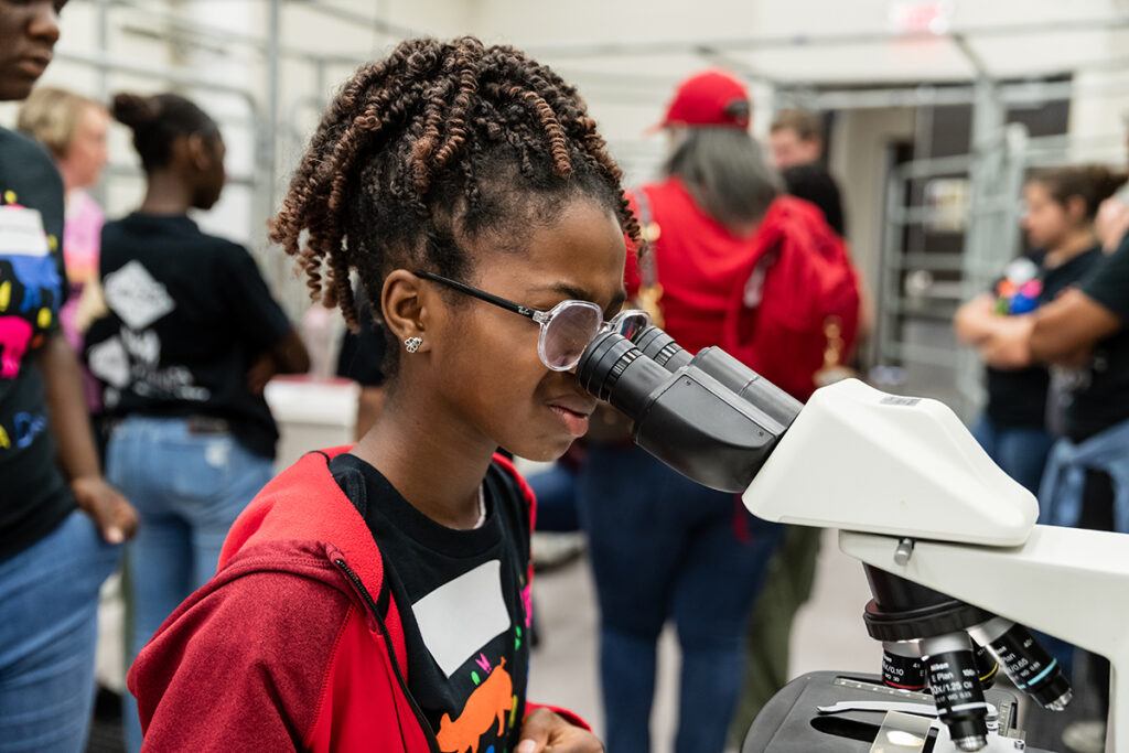 a young visitor to Vet for a Day looking through a microscope
