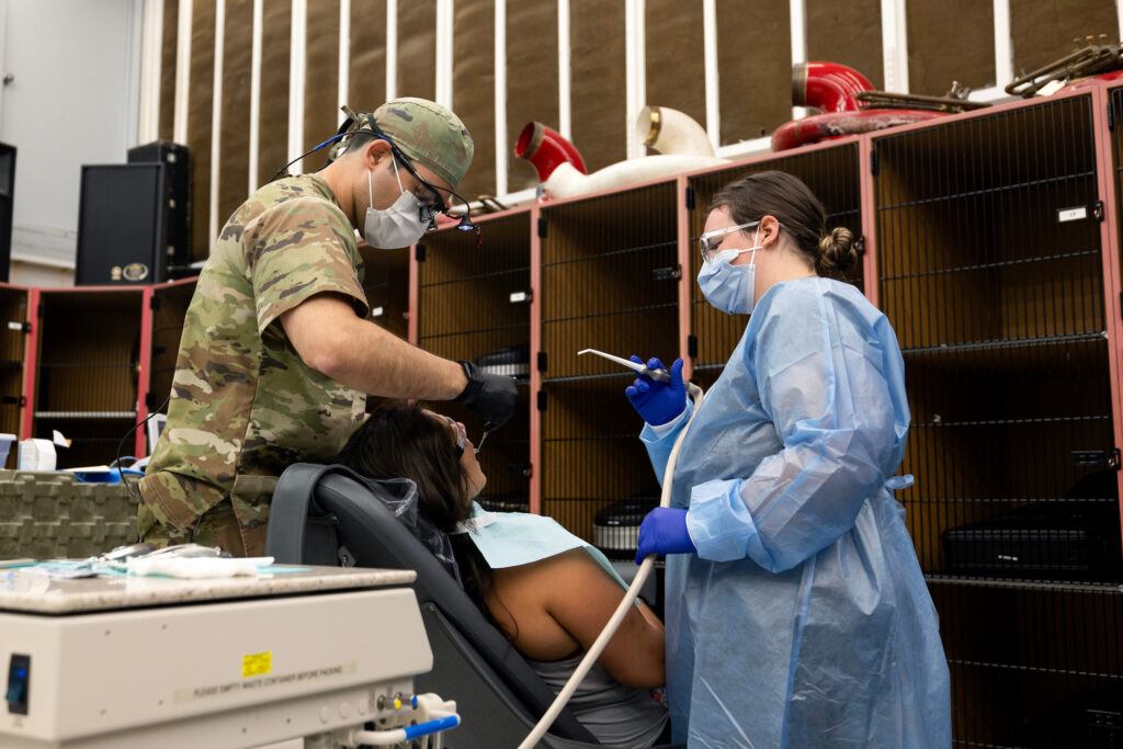 a photo of a man and a woman in surgical masks treating a patient