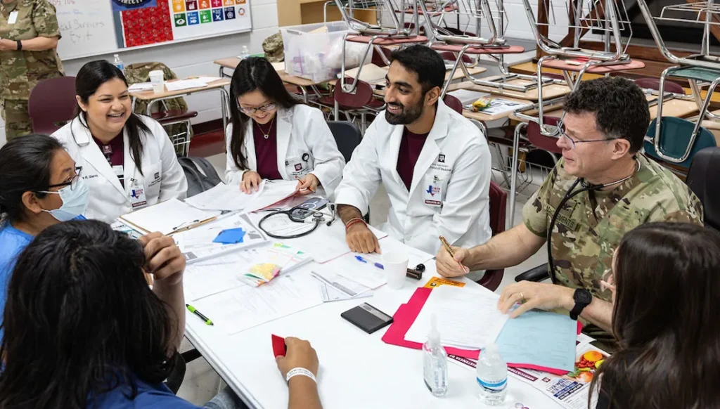 Students and health professions at a table talking