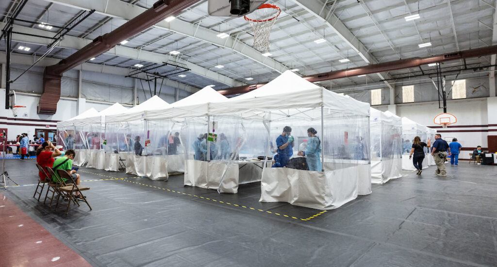 a photo of a row of plastic tents in a gymnasium