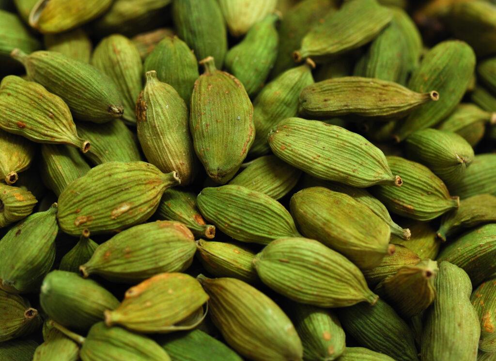 A close up view of many green Cardamom Pods. Fills the frame.