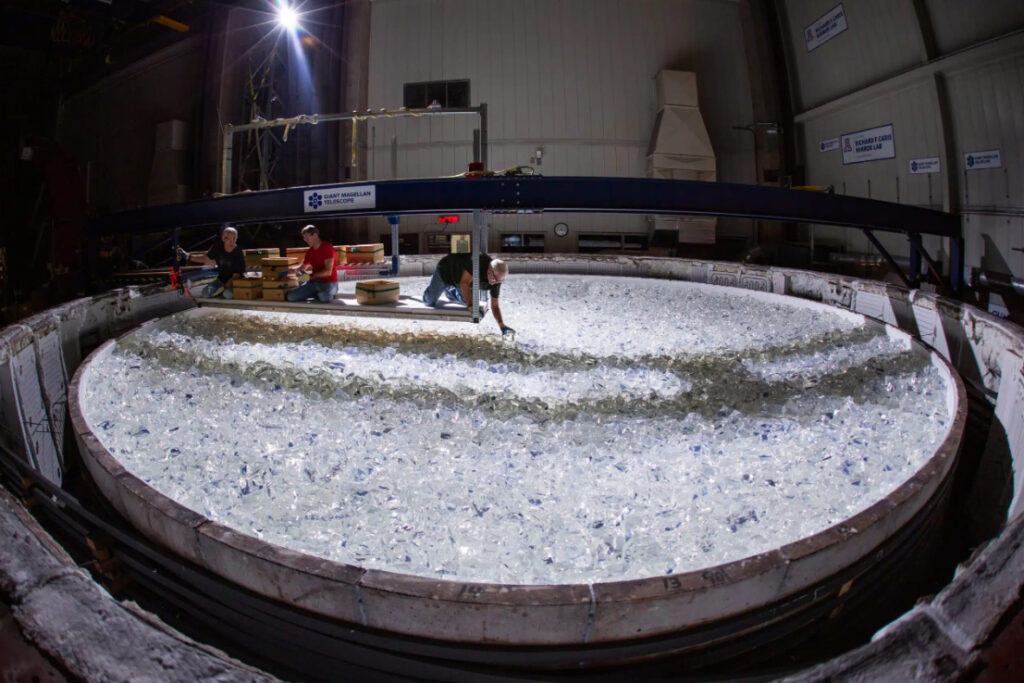A piece of glass being placed into the mold for Mirror 7 for the Giant Magellan Telescope. The process of casting each of the project’s seven giant mirrors involves melting nearly 20 tons of glass in a spinning furnace, located beneath a football stadium in Tucson at the University of Arizona's Richard F. Caris Mirror Lab at Steward Observatory.
