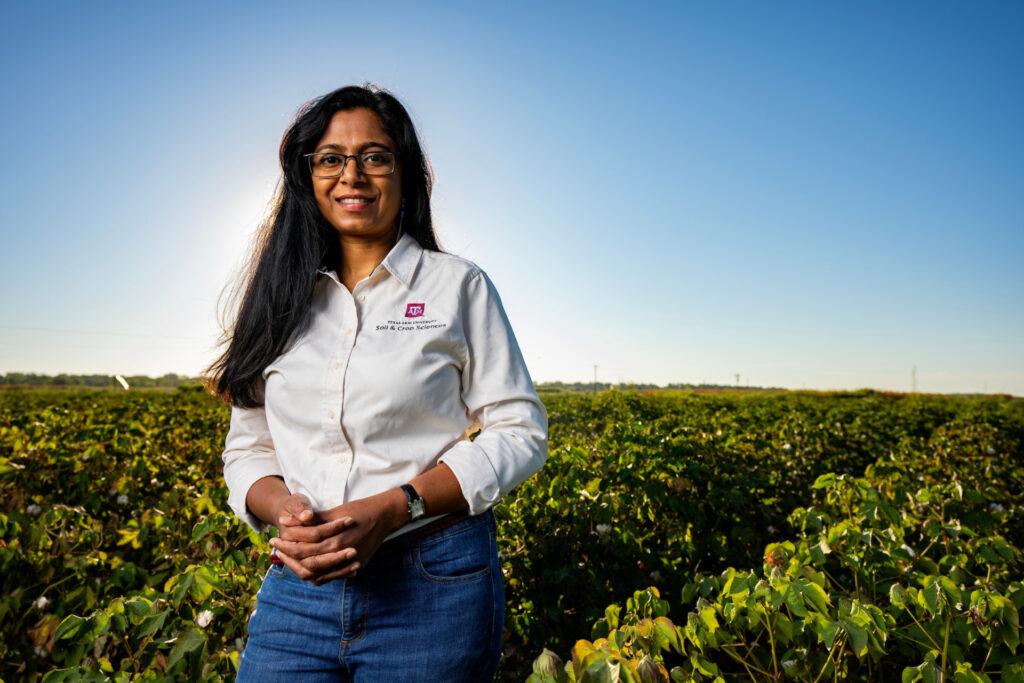 portrait of Nithya Rajan standing outdoors in a field of crops