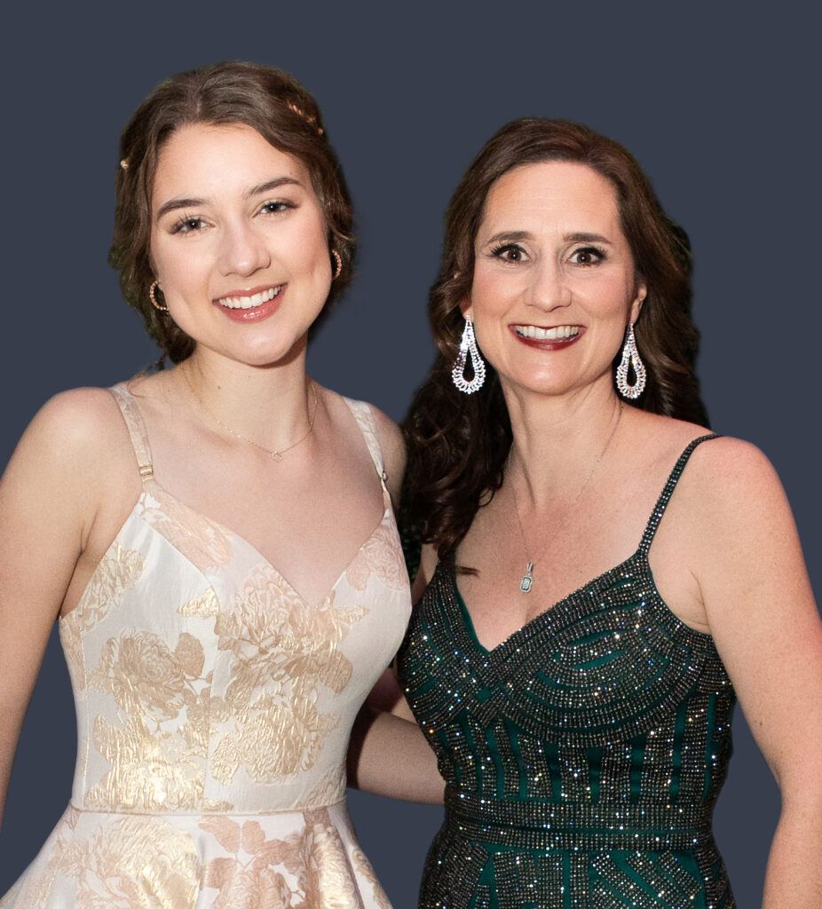 A photo of two women standing in formal dresses.