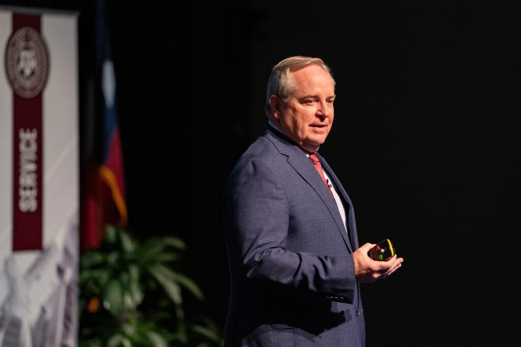 a photo of Mark A. Welsh III speaking onstage at Rudder Theatre