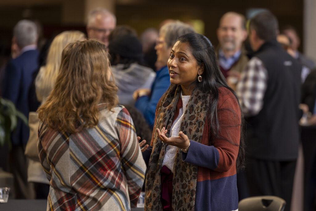 A photo of two women talking outside Rudder Theatre prior to the State of the University address.