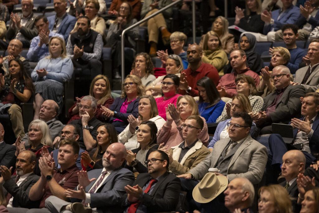 a photo of a crowd of people applauding inside Rudder Theatre.
