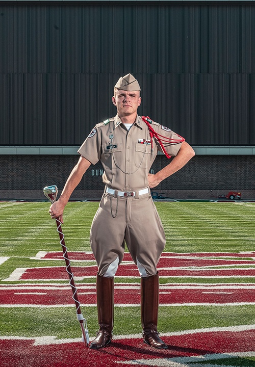 Mahlen stands on the band practice field holding the mace