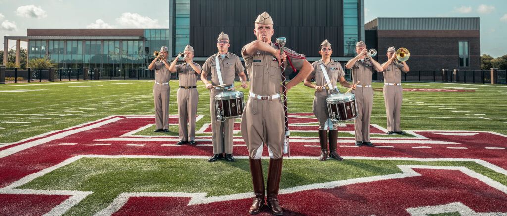 Cade Mahlen ’24 standing with other band members in formation on the Aggie Band practice field