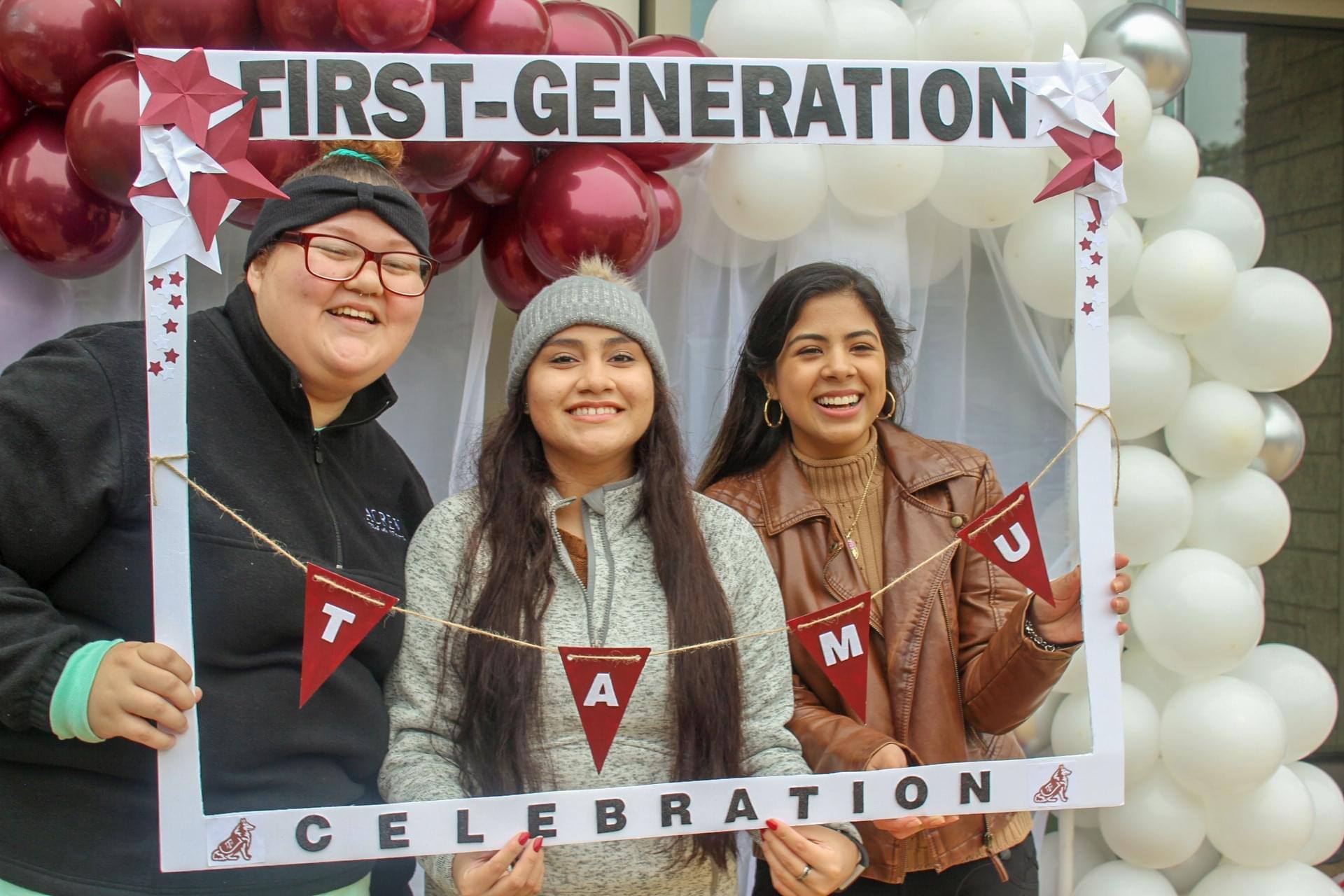 a family poses in a frame that says first-generation celebration, TAMU