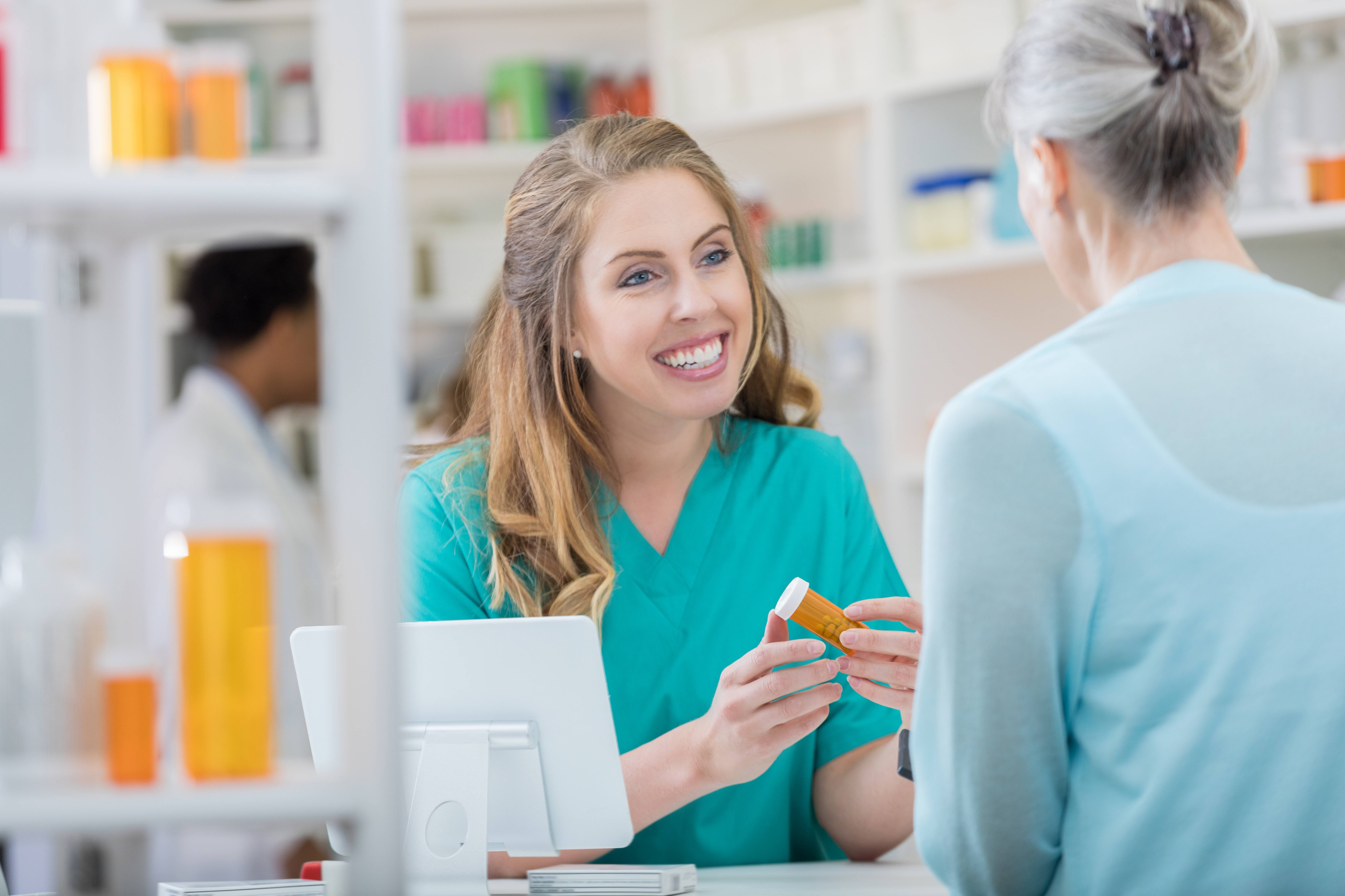 A photo of a woman in a pharmacy working with a customer.