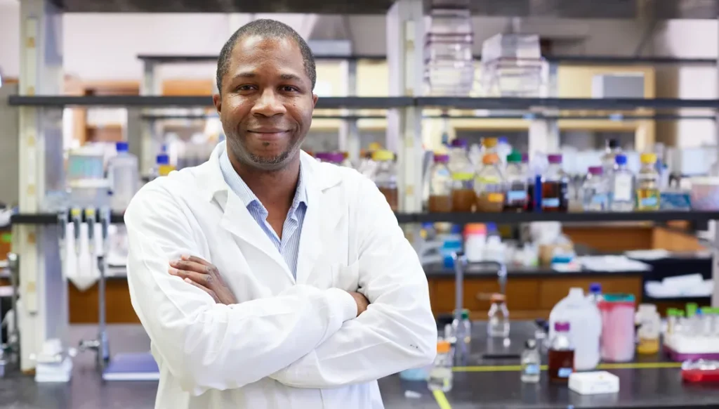 Portrait of Julian Hurdle standing in a lab with his arms crossed