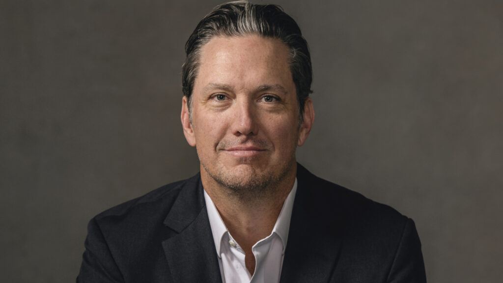 A portrait of R. Ethan Braden sitting at a desk.