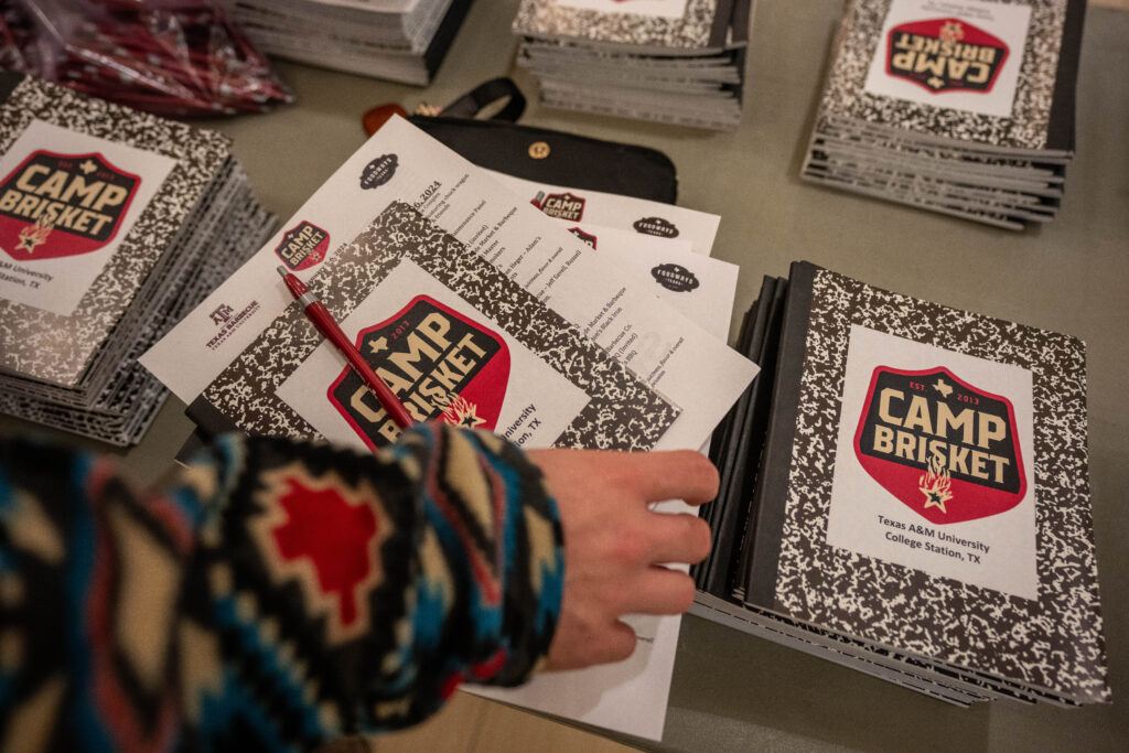 a photo showing stacks of notebooks with the Camp Brisket logo